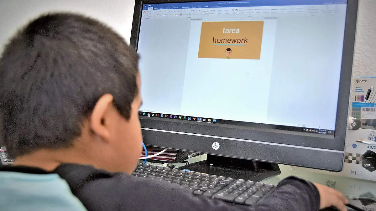 niño sentado frente a computadora